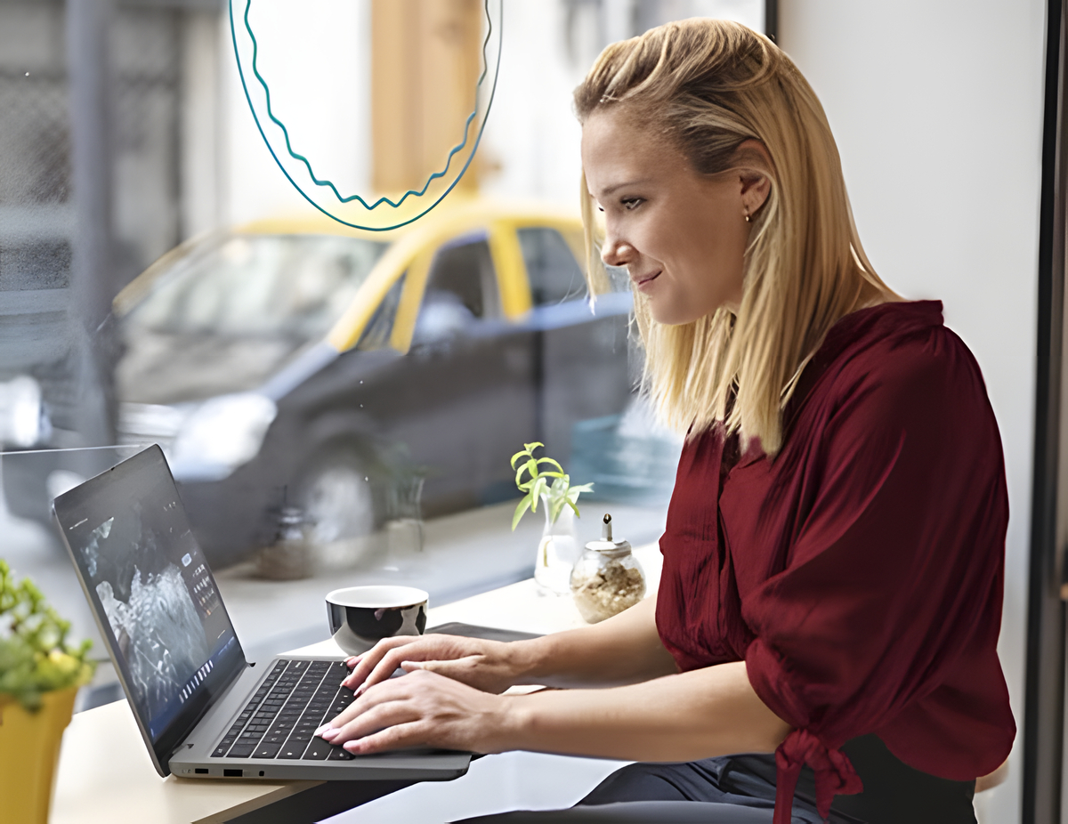 A person in a red top uses a IdeaPad Slim 3i Chromebook Gen 8 (14 Intel) in a café.
